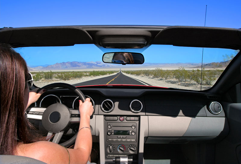 Woman driving car on empty road